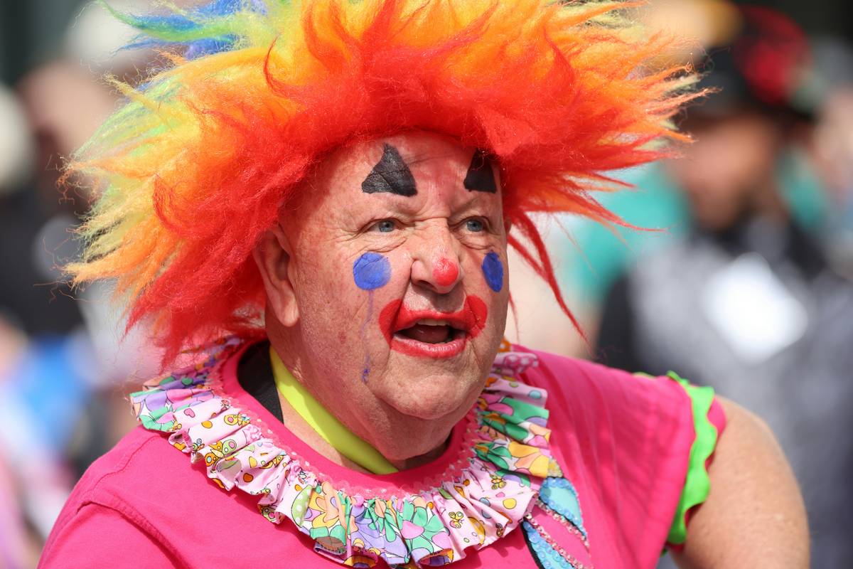 Close-up of actor wearing bold theatrical character makeup with prosthetics and vibrant colors